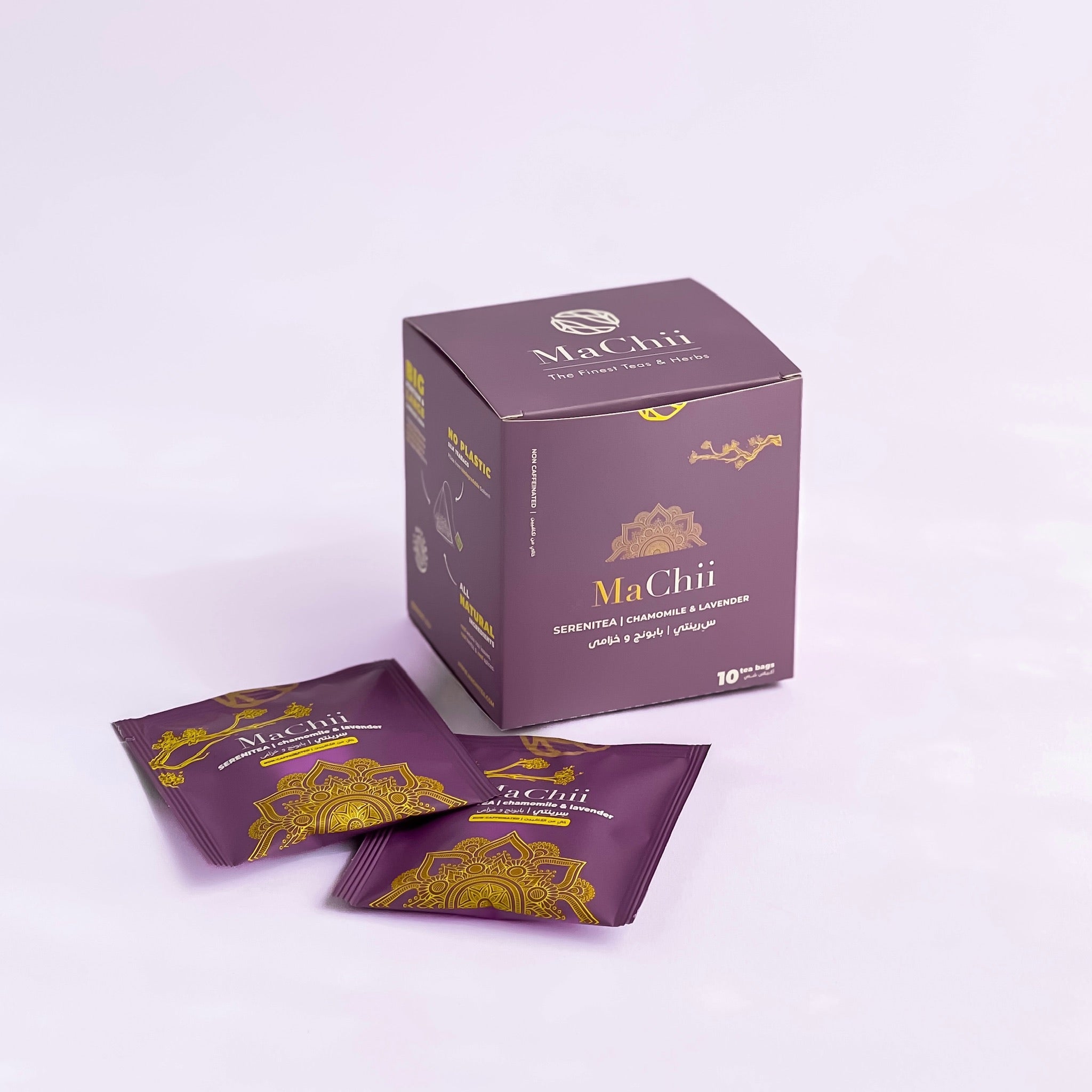 organic serenitea evenlopes from MaChii Tea next to their packaging box. Photo is shot on a purple background. The tea box has a mandala on it.